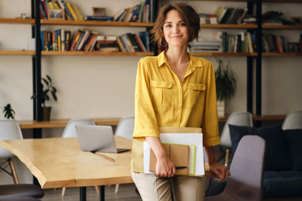 Female architect leaning against desk