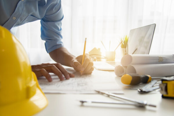 close-up of architects hands writing on desk